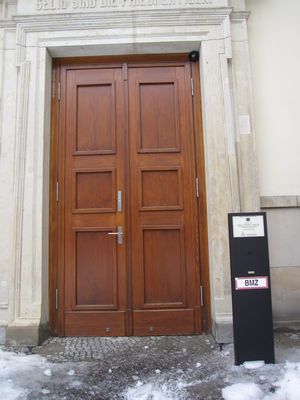 At the step-free entrance, press the button and someone will unlock the door.